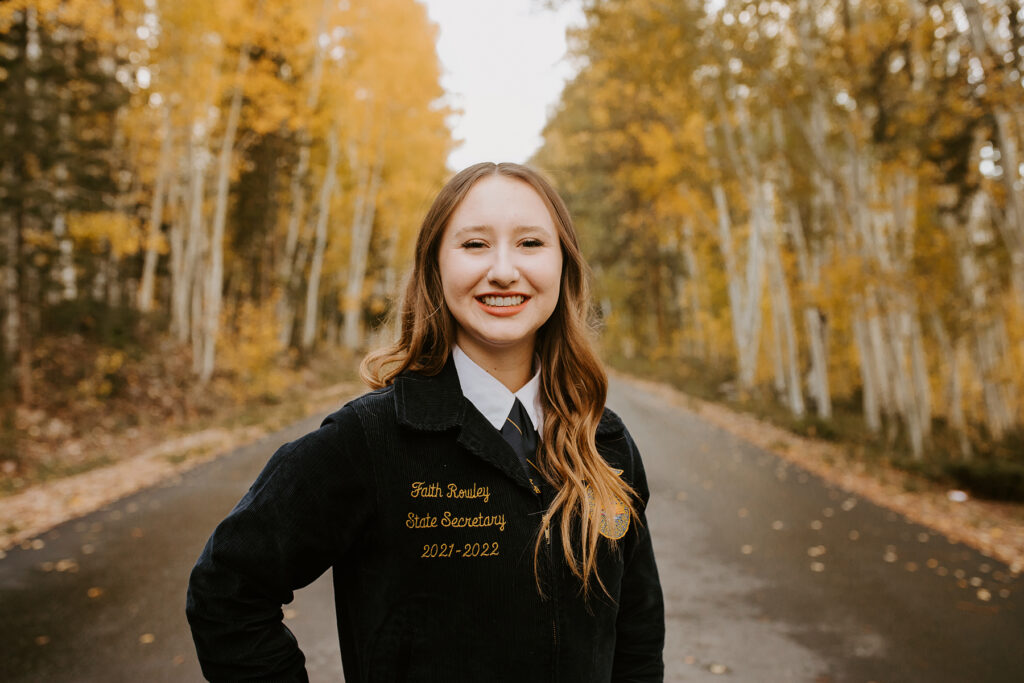 Faith standing in front of trees in FFA Official Dress